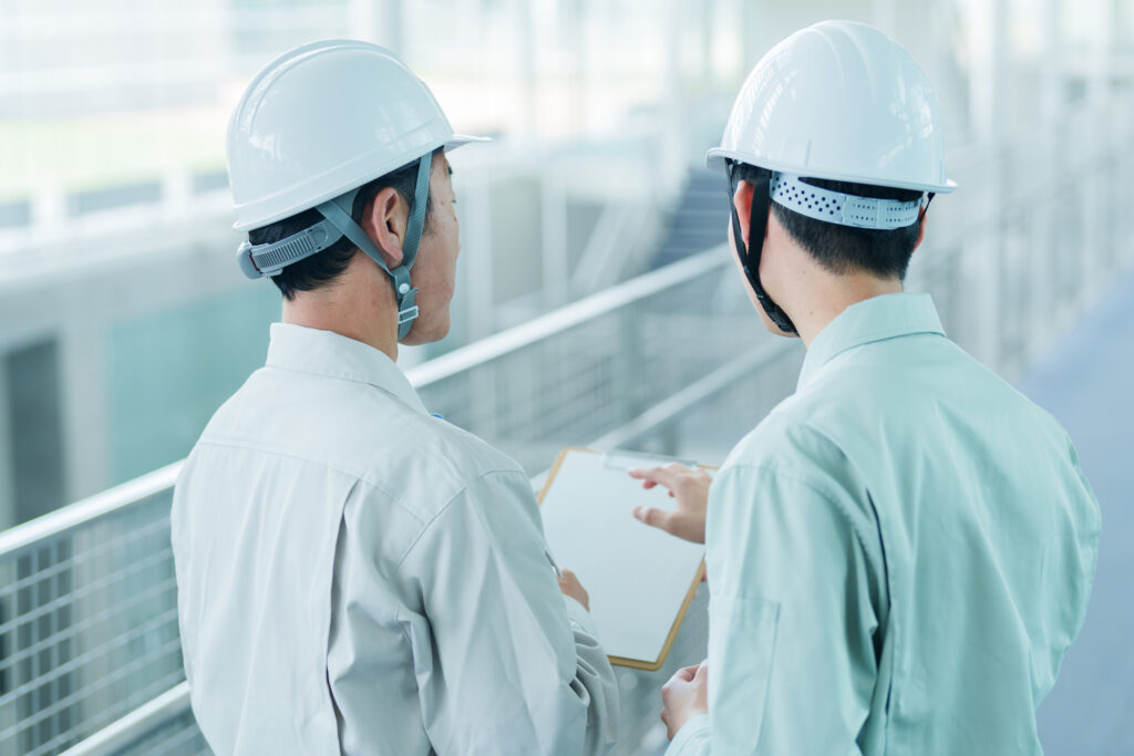 設備図面を確認して再開計画を立てる日本人の技術者